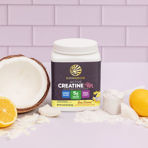 Sunwarrior Active Creatine for Her container with yuzu, coconut, powder, and sliced fruit on lavender tiles