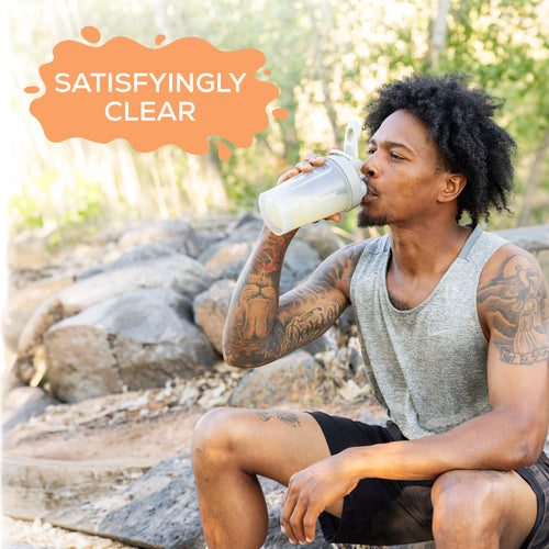 Man with tattoos drinking a clear protein shake outdoors with "Satisfyingly Clear" text above