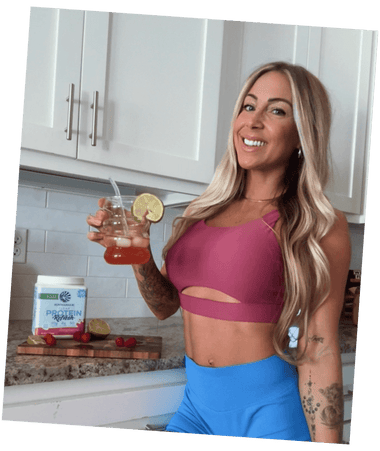 Woman in athletic wear holding a drink in a kitchen